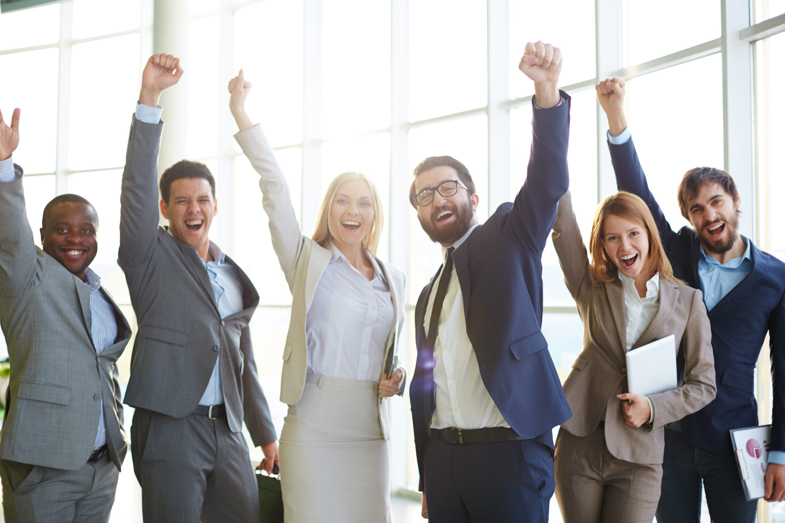 Excited co-workers Group of ecstatic business partners looking at camera with raised arms
